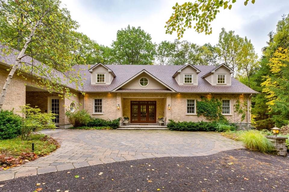 Home with a curved paver driveway